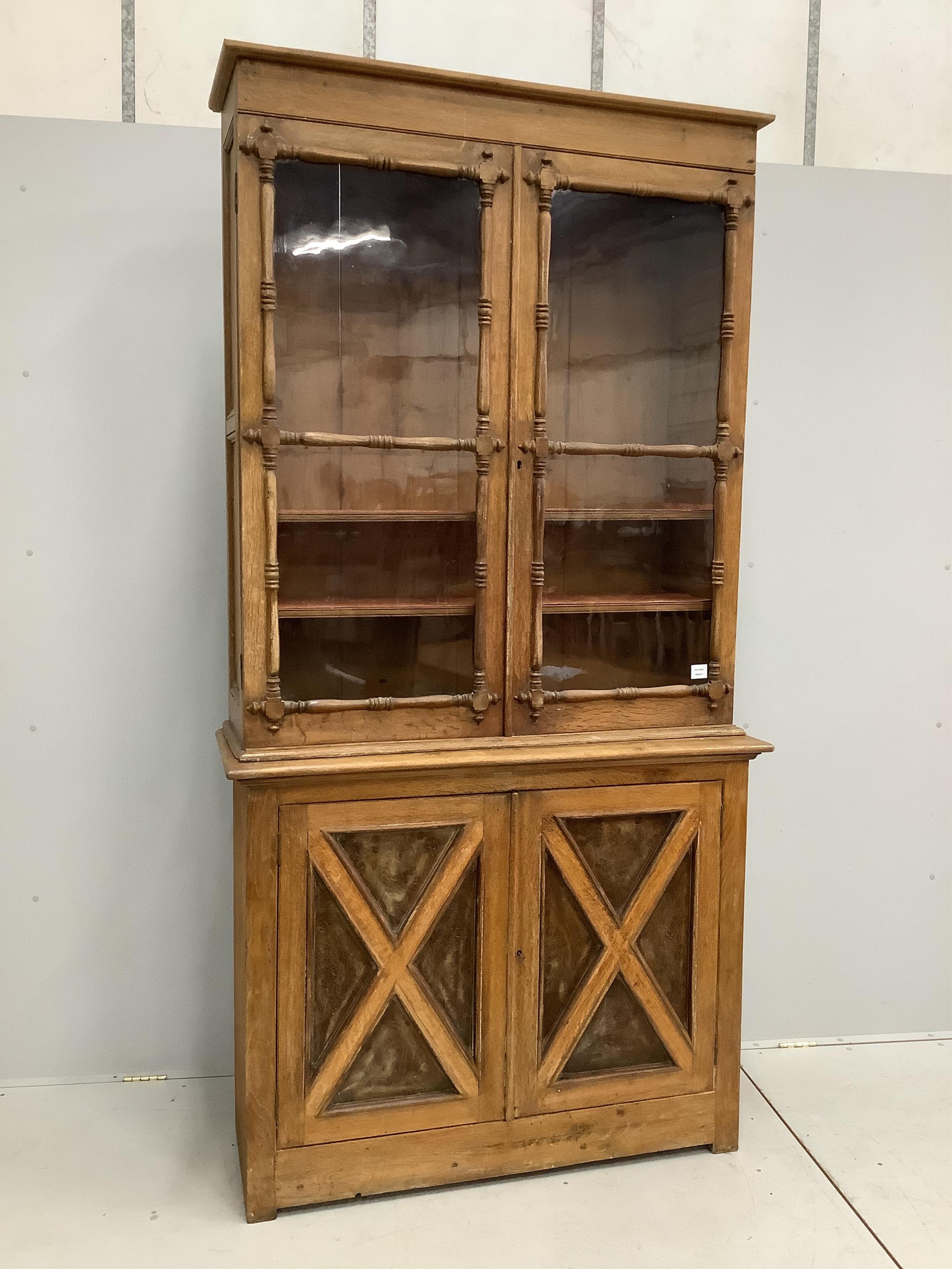 An early Victorian oak bookcase, width 120cm, height 232cm. Condition - some alterations and adaptions, fair